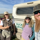 four people standing in front of a truck 