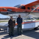 two people standing in front of an airplane