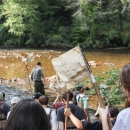 Several people walking into a river