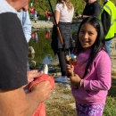 Little girl smiling with a fishing pole in front of a stream