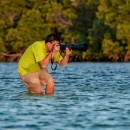 Ernesto Gomez taking photos of wildlife in a wetland