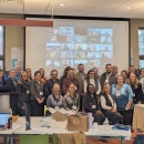 A group of people at a conference pose for a group photo. 