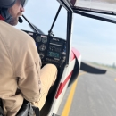 Close Up of Federal Wildlife Officer/Pilot taxis at an airport with the entry window/door open.