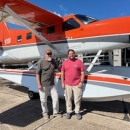 two people standing in front of an airplane