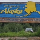 Watercraft inspector, Steve Wogtech, posed in Santa suit in front of Welcome to Alaska sign.