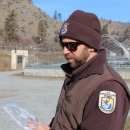 Service employee in uniform processes fish outside