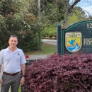 Scott standing next to the office sign.