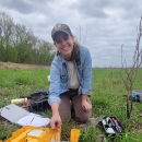 Biologist holds rattlesnake with tongs in the field