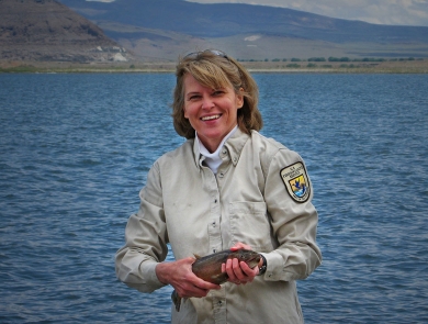 a woman holding a large fish