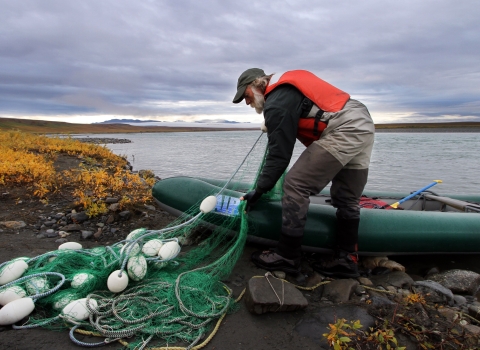 man folding a net into a raft