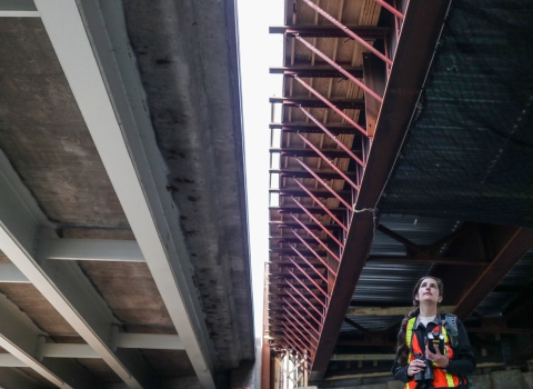 A biologist stands beneath two bridges - one complete and one under construction