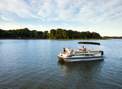 A family sits on a boat in a lake