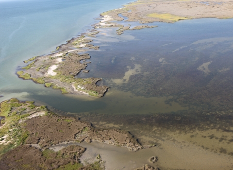 Aerial view of ocean breach and coastal flooding.