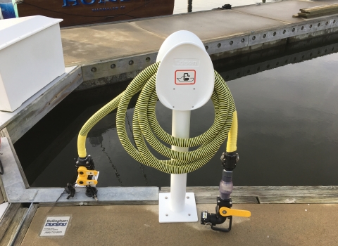 Pumpout station with yellow hose on dock. 