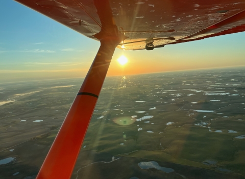 View from an airplane of the sunrise over the landscape