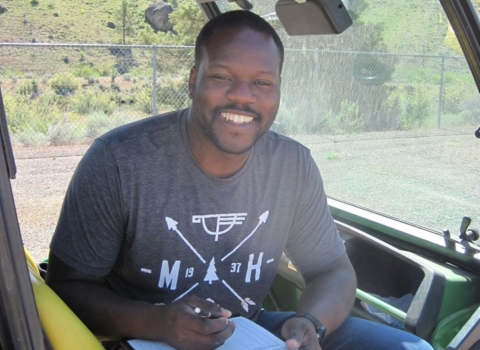 Rikeem Sholes, fish biologist, sitting in an OHV 