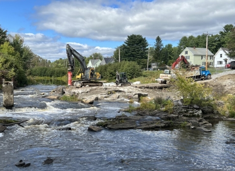 Construction equipment working on the side of a flowing river