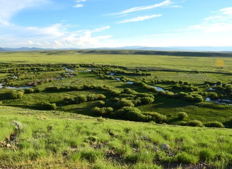 Distant view of a river winding through prairie.