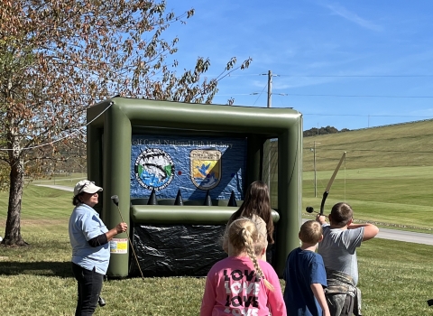 Kids shooting archery at a blow up target