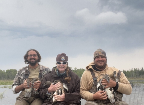 3 people holding ducks