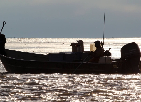 2 men on a boat in shimmery water