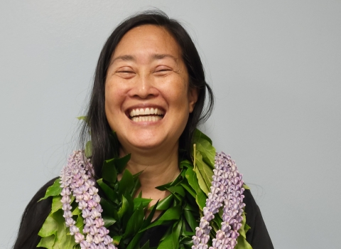 Woman with lots of lei smiling