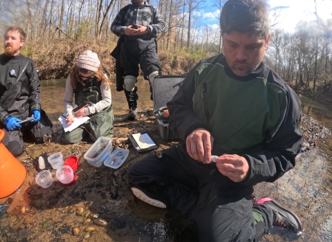 A man attached a PIT tag to a freshwater mussel